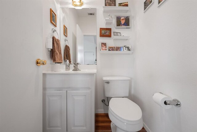 bathroom featuring vanity, hardwood / wood-style floors, and toilet