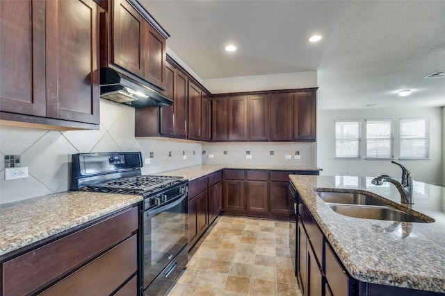 kitchen with sink, backsplash, stone counters, and black gas stove