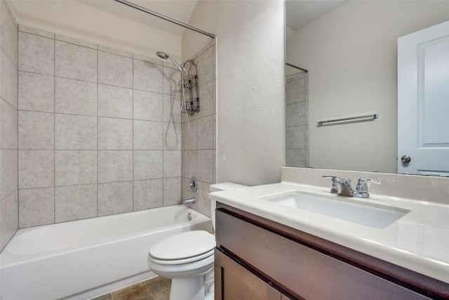 full bathroom featuring tiled shower / bath combo, vanity, tile patterned floors, and toilet