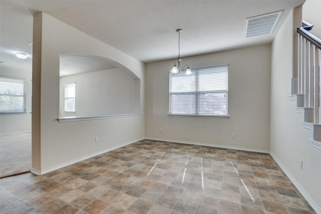 spare room featuring a notable chandelier