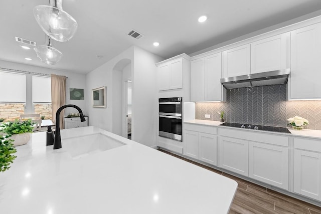 kitchen featuring sink, white cabinetry, pendant lighting, stainless steel double oven, and black electric stovetop