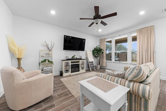 125 Jasmine Ln, Marble Falls, TX 78654 - living room with a ceiling fan, recessed lighting, dark wood-style flooring, baseboards, and a glass covered fireplace