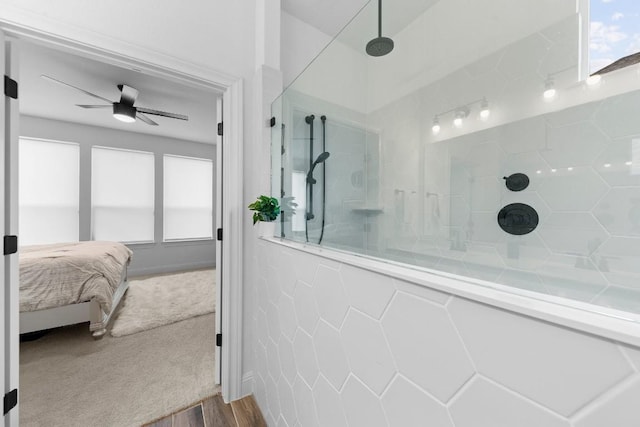 bathroom with tiled shower, hardwood / wood-style floors, and ceiling fan