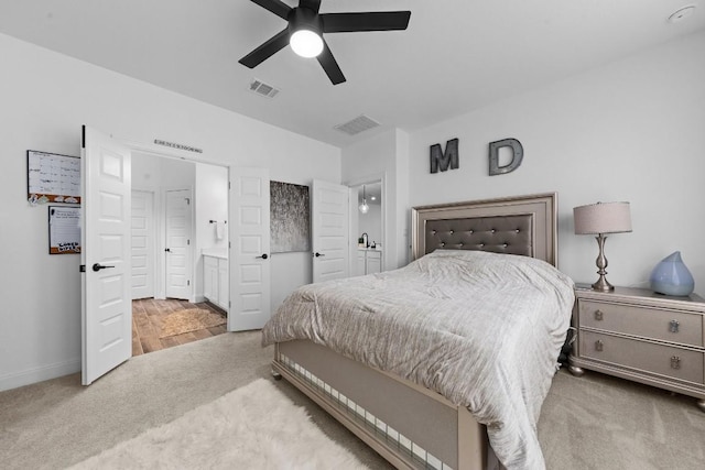 carpeted bedroom featuring ceiling fan and ensuite bath