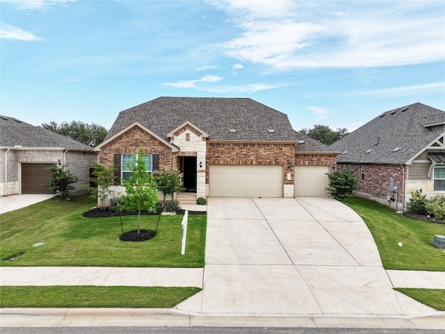 125 Jasmine Ln, Marble Falls, TX 78654 - french provincial home featuring an attached garage, a front yard, concrete driveway, brick siding, and a shingled roof