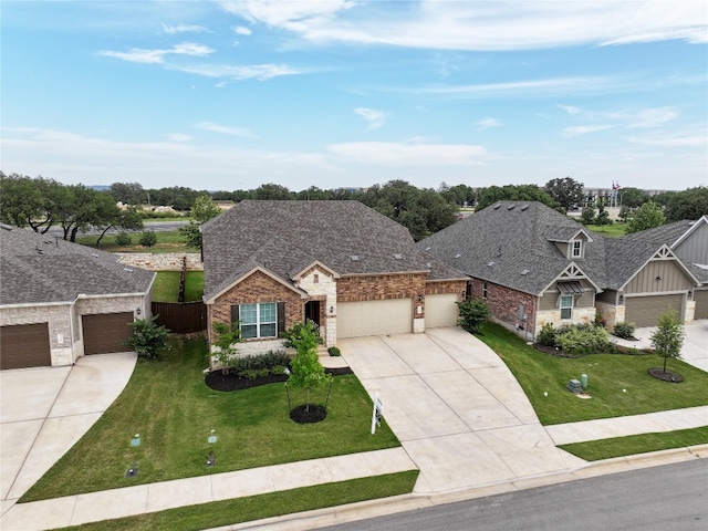 125 Jasmine Ln, Marble Falls, TX 78654 - view of front of house with an attached garage, concrete driveway, stone siding, a shingled roof, and brick siding
