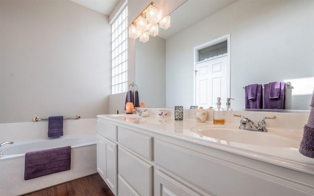 bathroom with hardwood / wood-style flooring, vanity, a bathing tub, and a healthy amount of sunlight