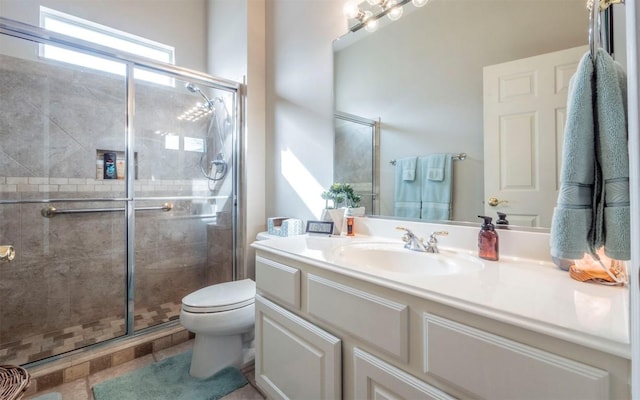 bathroom with vanity, a shower with door, and toilet