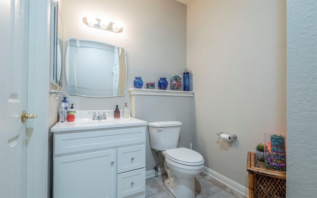 bathroom featuring vanity, tile patterned floors, and toilet