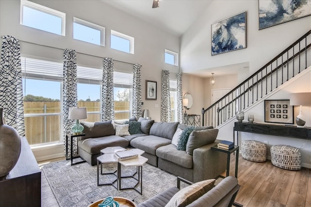 living room with a towering ceiling and hardwood / wood-style floors