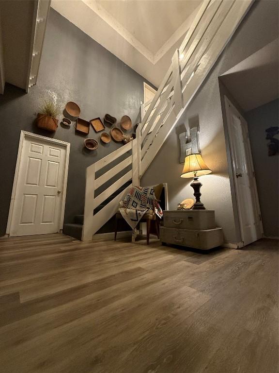 unfurnished room with hardwood / wood-style flooring and a towering ceiling