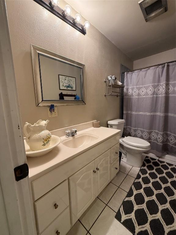 bathroom with vanity, curtained shower, tile patterned floors, and toilet