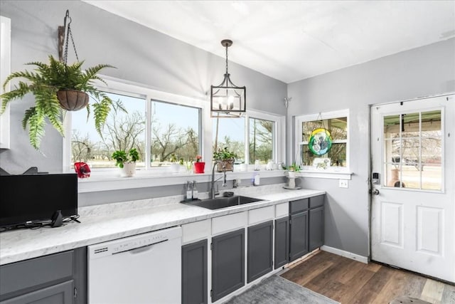 kitchen featuring decorative light fixtures, dishwasher, sink, a chandelier, and dark wood-type flooring