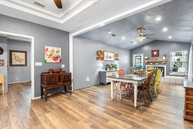 dining space with vaulted ceiling, ceiling fan, and light hardwood / wood-style floors