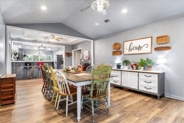 dining space with vaulted ceiling, ceiling fan, and light hardwood / wood-style floors