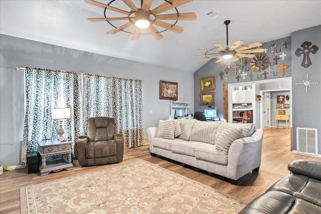 living room with hardwood / wood-style floors, vaulted ceiling, and ceiling fan