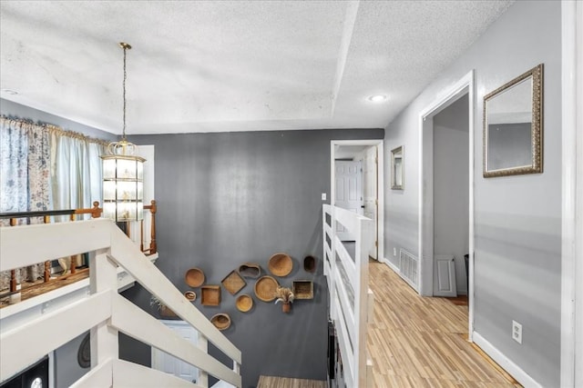 interior space with a textured ceiling and light wood-type flooring