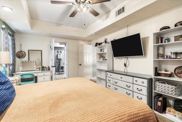 bedroom with ceiling fan and a tray ceiling