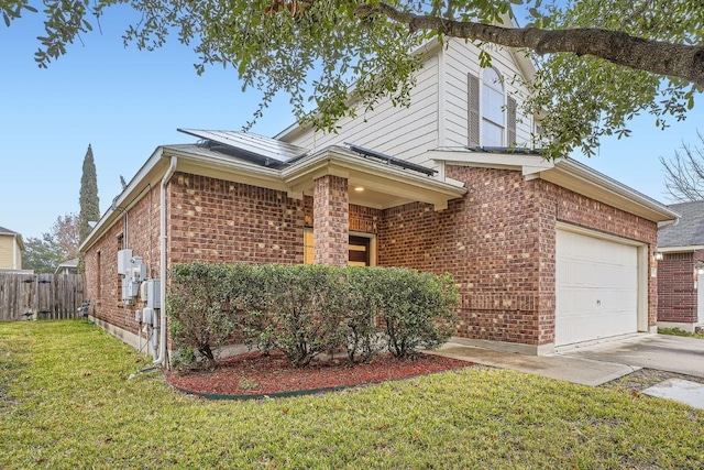 traditional-style home featuring a garage, a front yard, brick siding, and fence