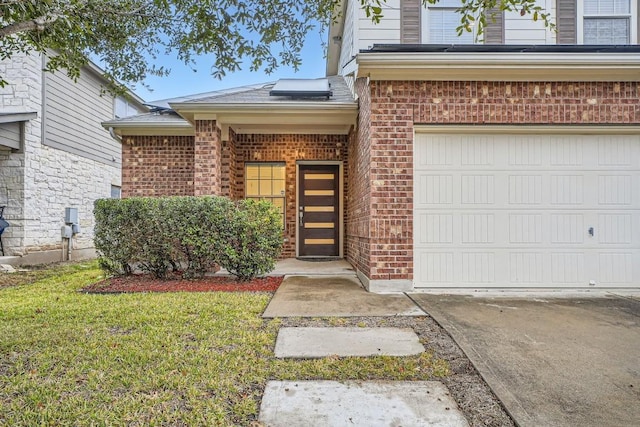 doorway to property featuring a garage and a lawn