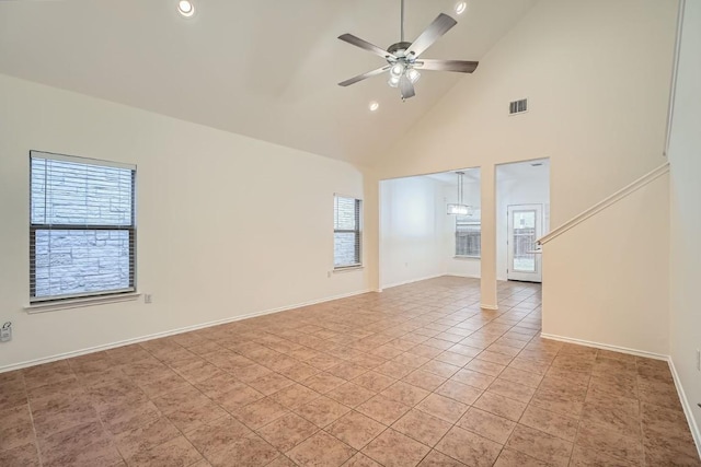 empty room with light tile patterned flooring, ceiling fan, and high vaulted ceiling