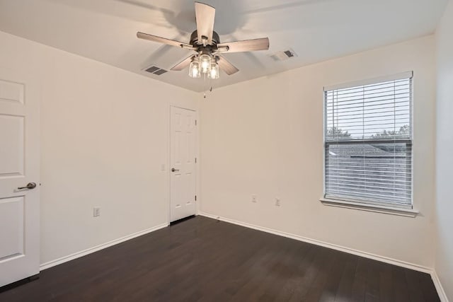 spare room with dark hardwood / wood-style flooring and ceiling fan