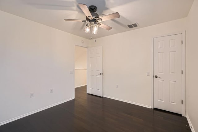 empty room with dark wood-type flooring and ceiling fan