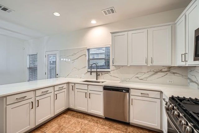 kitchen featuring white cabinetry, stainless steel dishwasher, sink, and decorative backsplash