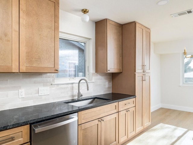 kitchen with sink, tasteful backsplash, light hardwood / wood-style flooring, dishwasher, and dark stone counters