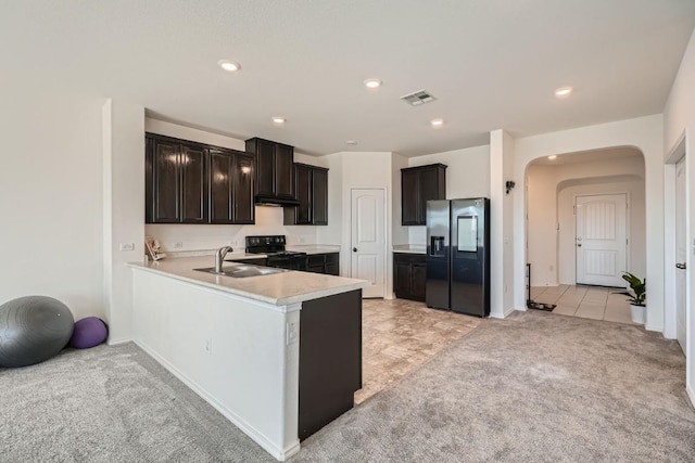 kitchen with sink, black range with electric cooktop, light carpet, stainless steel fridge with ice dispenser, and kitchen peninsula