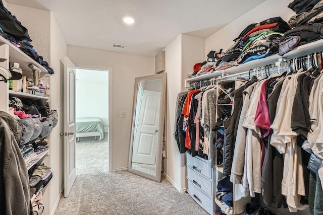 walk in closet with light carpet