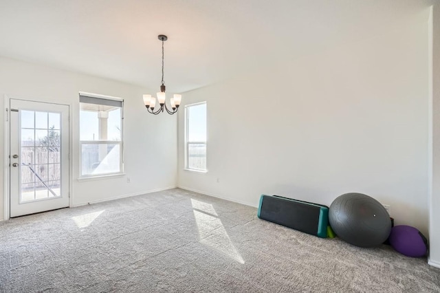 unfurnished room featuring light carpet and a notable chandelier