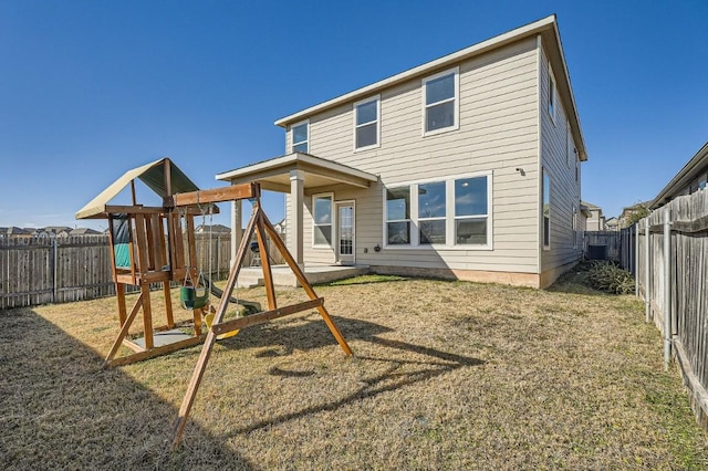 rear view of property featuring a playground and a lawn