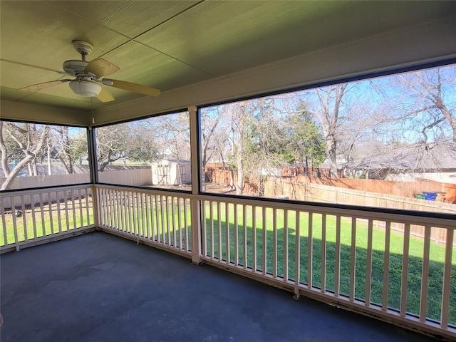 unfurnished sunroom featuring ceiling fan and plenty of natural light