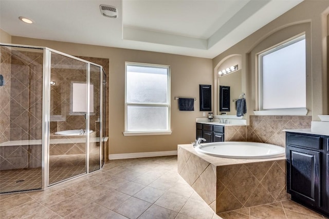 bathroom with vanity, a tray ceiling, tile patterned floors, and separate shower and tub