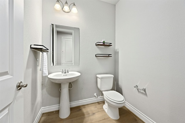 bathroom with hardwood / wood-style flooring and toilet