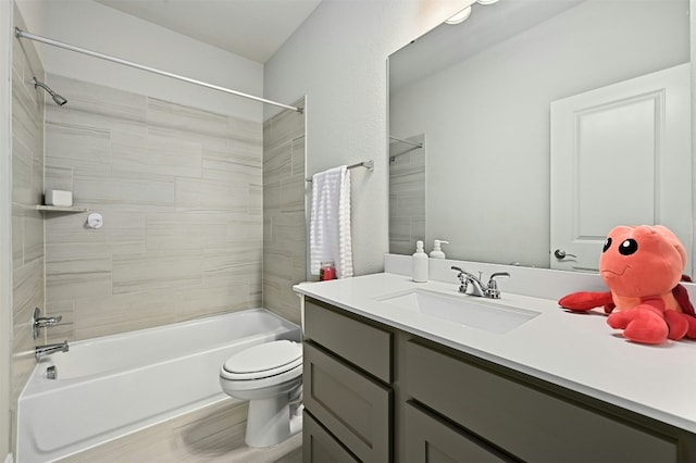 full bathroom with tiled shower / bath, vanity, and toilet