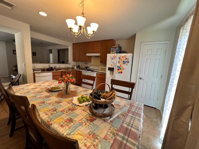 tiled dining area featuring sink and an inviting chandelier