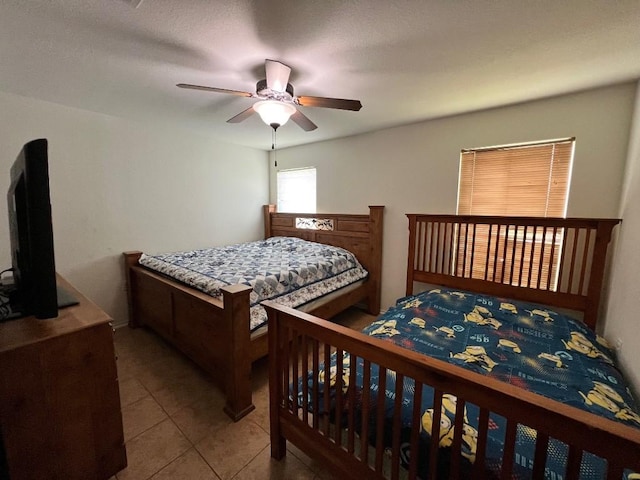 tiled bedroom featuring ceiling fan