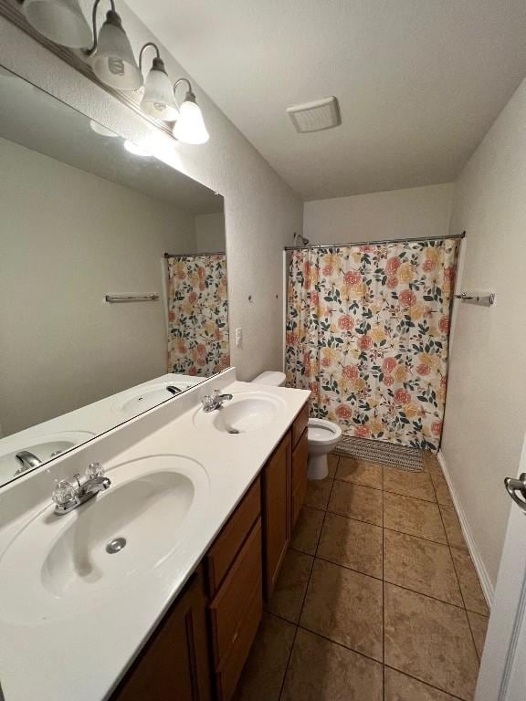 bathroom with a shower with shower curtain, vanity, toilet, and tile patterned flooring