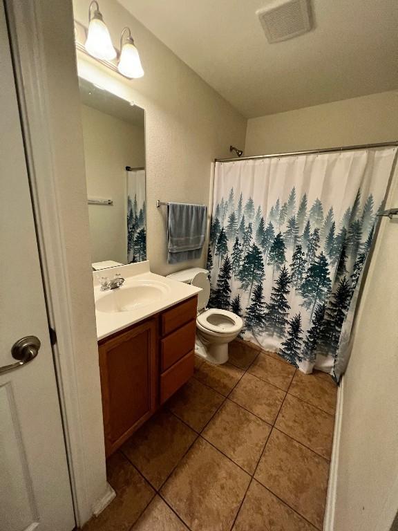 bathroom with a shower with shower curtain, vanity, toilet, and tile patterned flooring