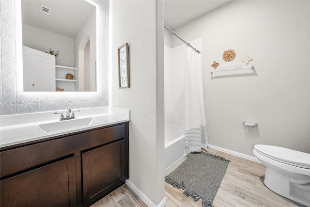 full bathroom featuring shower / tub combo, hardwood / wood-style floors, vanity, decorative backsplash, and toilet