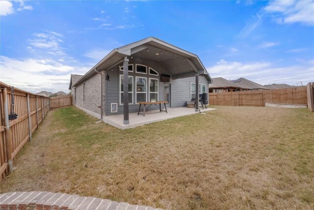 back of house featuring a yard and a patio area