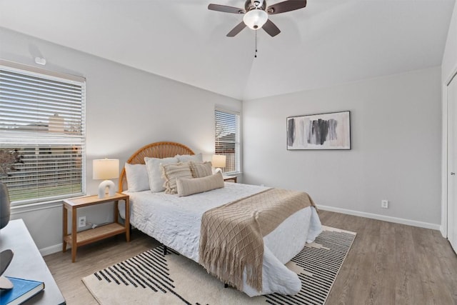 bedroom featuring hardwood / wood-style flooring, vaulted ceiling, and ceiling fan