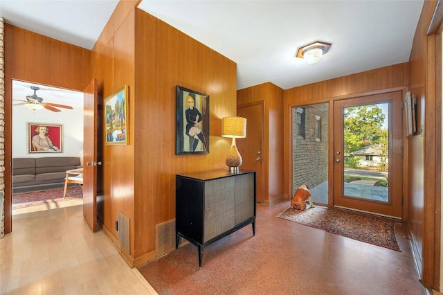 foyer featuring wooden walls