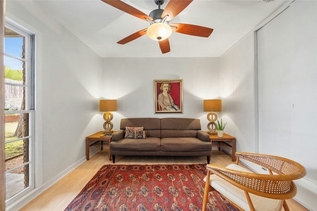 living room with light hardwood / wood-style flooring and ceiling fan