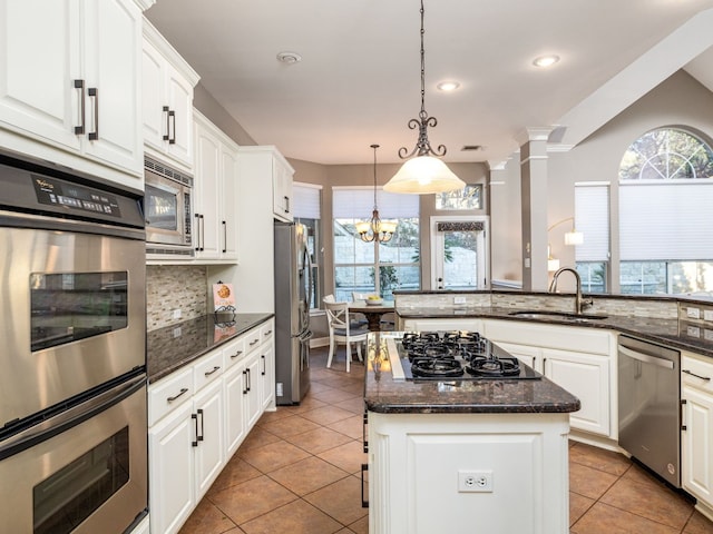 13312 Country Lake Dr, Austin, TX 78732 - kitchen with stainless steel appliances, a sink, tasteful backsplash, light tile patterned floors, and a center island
