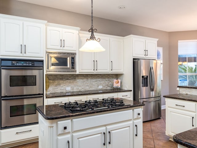 13312 Country Lake Dr, Austin, TX 78732 - kitchen with appliances with stainless steel finishes, backsplash, white cabinetry, and hanging light fixtures