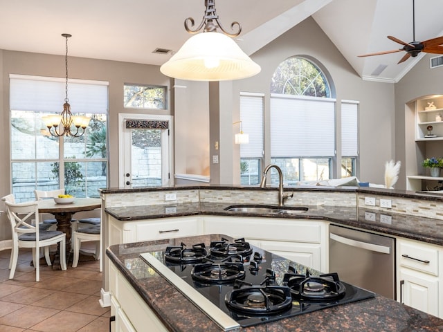 kitchen featuring sink, dark stone countertops, stainless steel dishwasher, black gas stovetop, and white cabinets