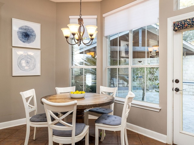 dining room featuring a notable chandelier and dark tile patterned flooring